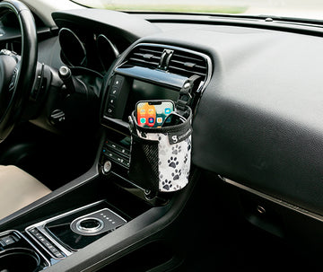 Paw printed fabric small bin hooked into car's air vent, storing phone and sunglasses, with pens in the front mesh pocket.