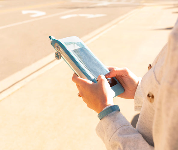 Person holding a tablet outdoors on a sunny day
