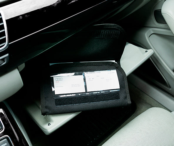 Black fabric organizer in car glove compartment opened to display ID card windows