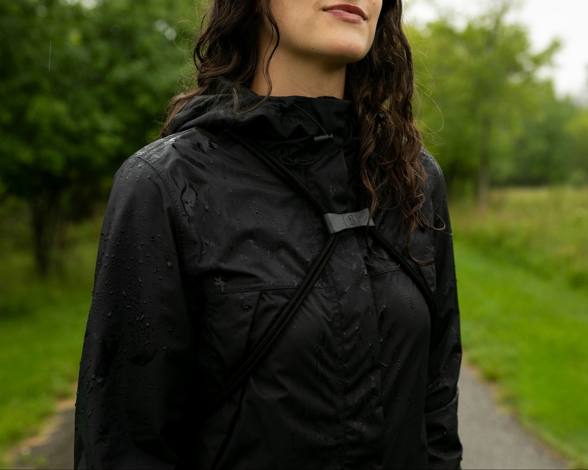 GWP-13891BG
Person wearing a black raincoat standing outdoors on a path with greenery.