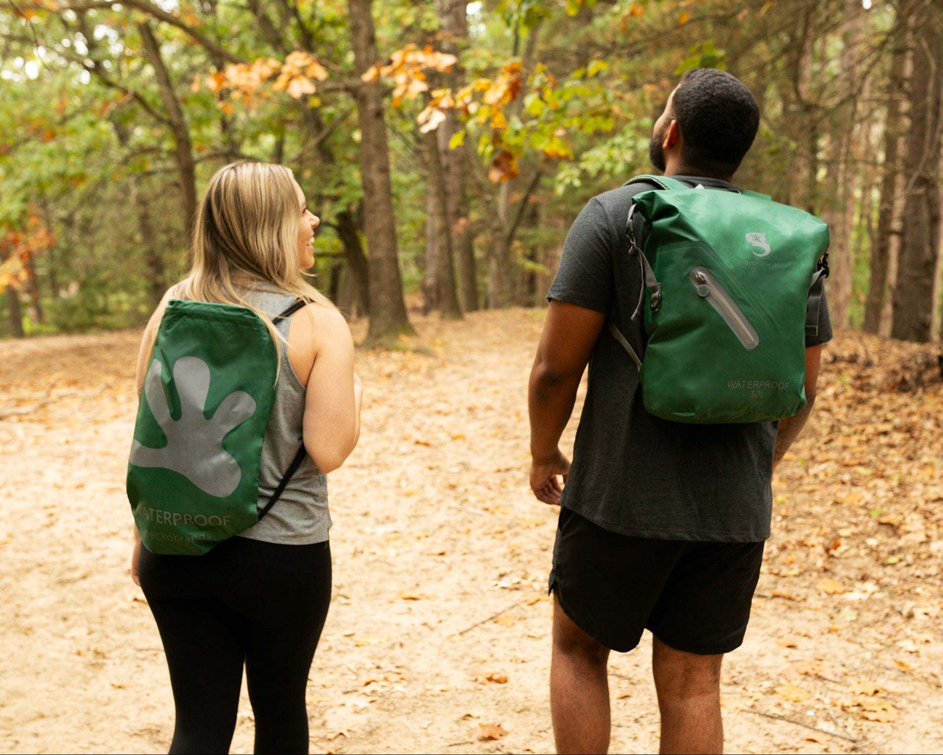 GWP-17578HG
Two people walking on a forest path with green backpacks.