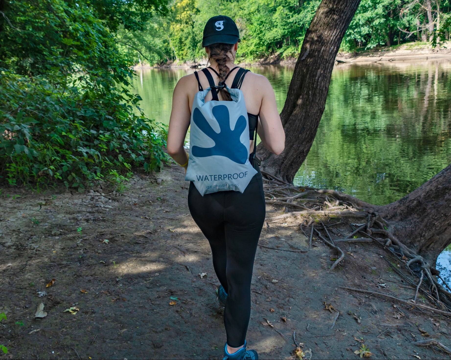 GWP-46900GN
Person walking along a path by a lake with a backpack labeled 'Waterproof'.