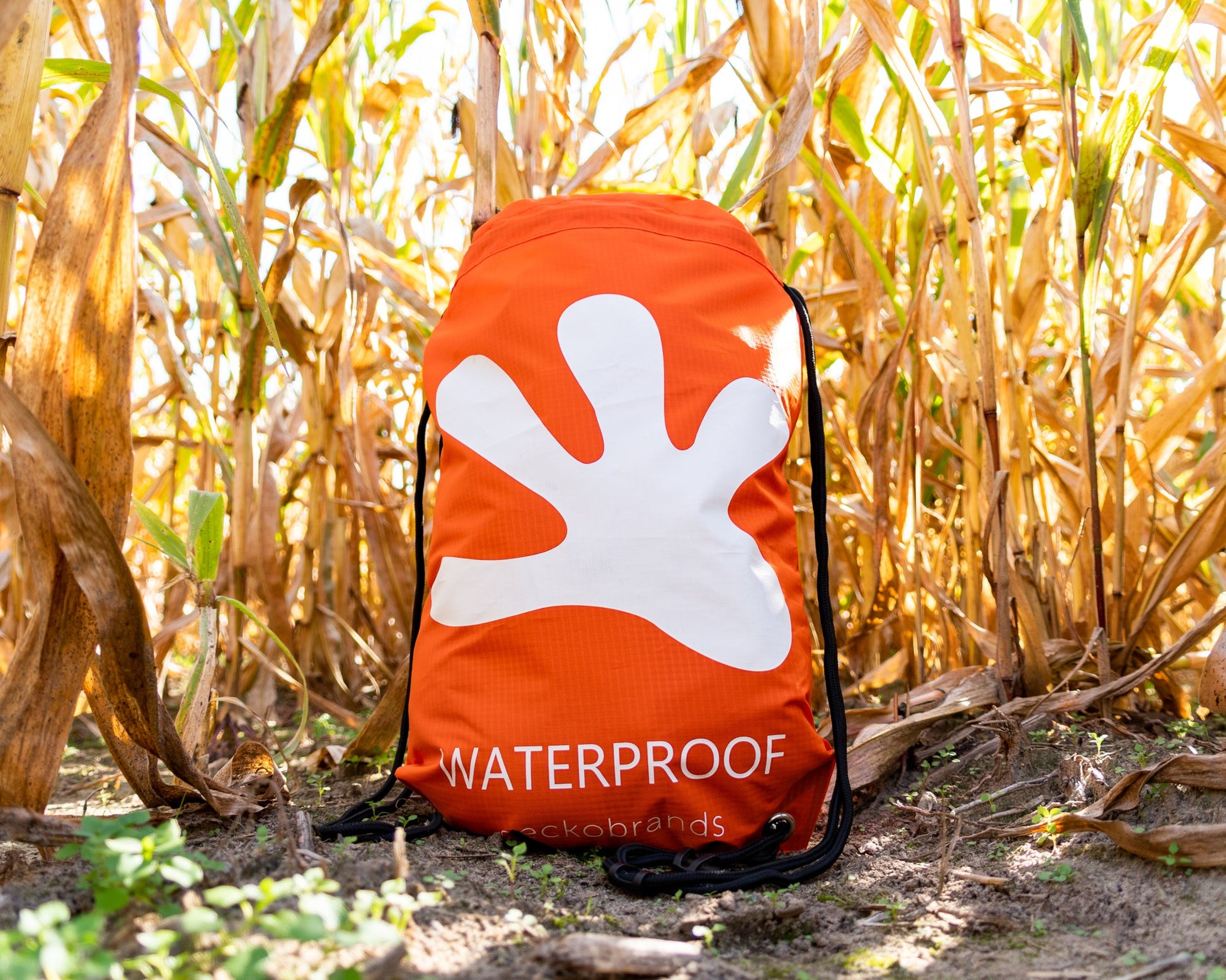 GWP-47013OW
Orange drawstring bag with a white logo and 'Waterproof' text in a cornfield
